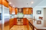 Kitchen with granite counters, stainless steel appliances.